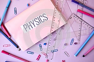 School book. physics with supplies stationery on color background, back to school