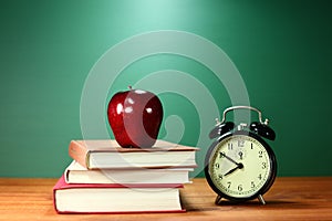 School Books, Apple and Clock on Desk at School