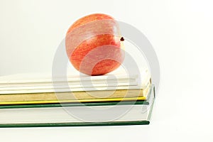 School books with apple in white background