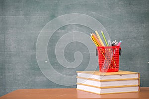 School books on desk, Back to school supplies. Books and blackboard on wooden background, education concept