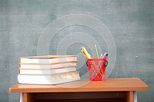 School books on desk, Back to school supplies. Books and blackboard on wooden background, education concept