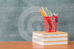 School books on desk, Back to school supplies. Books and blackboard on wooden background, education concept