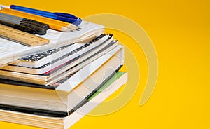 School books and supplies on a yellow background