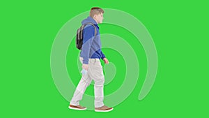 School boy in casual clothes walking and taking off medical mask on a Green Screen, Chroma Key.