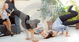 School boy doing back flip on the desk in the classroom