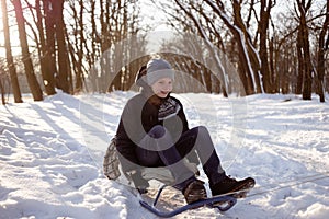 school boy enjoying a sleigh ride. Children sledges. child rides in a sleigh. Children play outside in the snow. Camping