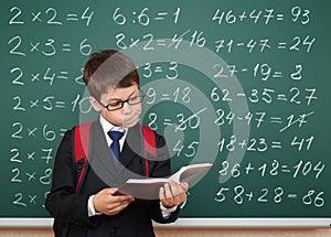 School boy exercise math on board