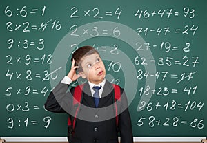 School boy exercise math on board