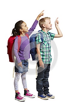 School boy and girl with backpacks pointing