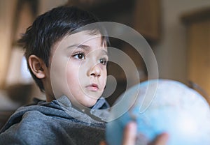 School boy learning about Geography, Kid is looking out deep in thought while holding a globe, World Children s Day, Education and