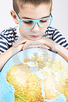 School boy looking at globe