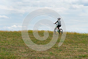 School boy in the protective helmet riding bike in the Park