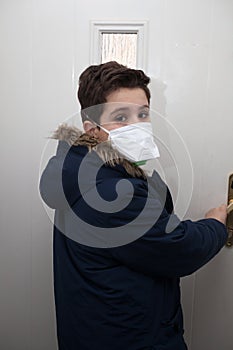 A school boy returning home with a face mask to protect against viruses