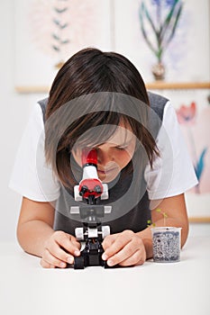 School boy in science class with microscope