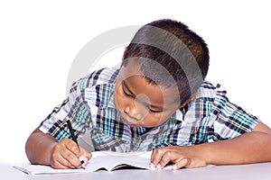 School boy sitting and writing in notebook