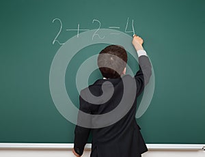 School boy solve math on school board