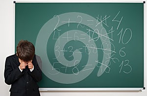 School boy solve math on school board