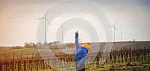 School boy stand on the wind farm. Wind turbines are alternative electricity sources. Future of kid and sustainable