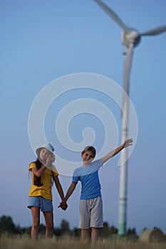 School boy stand on the wind farm. Wind turbines alternative electricity sources. Future of kid and sustainable