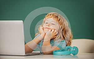 School boy studying math during online lesson in classroom, online education. School boy dreaming on lesson.