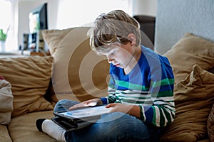 School boy with tablet computer. Schoolchild study online. Electronic device for learning, studying and playing at home