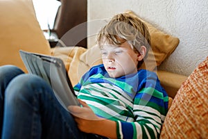 School boy with tablet computer. Schoolchild study online. Electronic device for learning, studying and playing at home