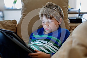 School boy with tablet computer. Schoolchild study online. Electronic device for learning, studying and playing at home