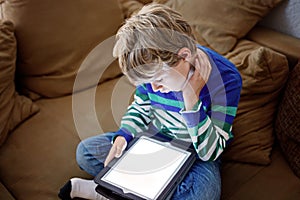 School boy with tablet computer. Schoolchild study online. Electronic device for learning, studying and playing at home