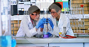 School boys doing chemical experiment in laboratory at school