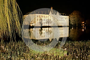 School building in the mirror of pond by night in Litovel photo