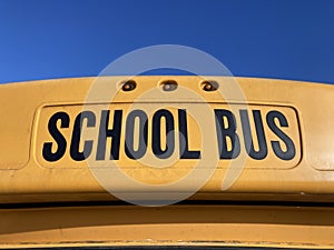 School bus sign on yellow school bus. Close up