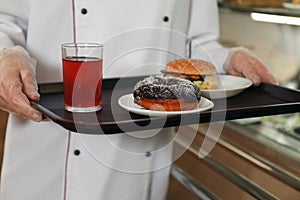 School canteen worker with tasty food near serving line, closeup