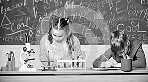 School chemistry lesson. School laboratory. Girl and boy smart students conduct school experiment. Describe chemical