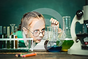 School chemistry lessons. Child in the class room with blackboard on background. School concept. Chemistry science
