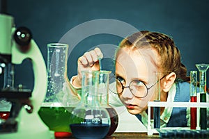 School chemistry lessons. Child in the class room with blackboard on background. School concept. Chemistry science