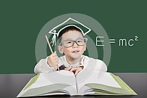 School child boy in glasses studying book