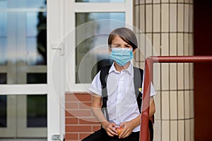 School child, boy wearing medical masks, going back to school after the summer vacation, kid going to school