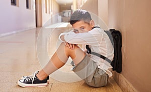 School child, bullying and sad student on ground for depression, anxiety and autism or learning problem in hallway. Boy