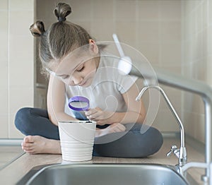 School child holding in hand magnifying glass. Earth Day. World Environment Day. Environmental education. Distance learning.