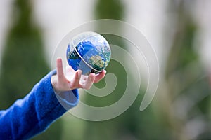 School child, holding small globe, looking sad at the world during Covid 19 pandemic