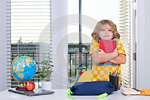 School child. Kid boy from elementary school doing homework at home. Pupil go study. Clever schoolboy learning. Portrait