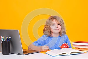 School child using laptop computer. Nerd school kid isolated on studio background. Clever child from elementary school