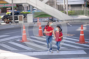 School child wearing a face mask during coronavirus and flu outbreak. sibling girl going back to school after covid-19 quarantine