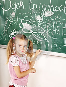 School child writing on black board.