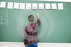 School child writing blackboard