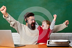 School children. Hurray. Father and son. Child showing winner sign. Chalkboard ready for text