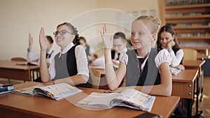 School children raising their hands ready to answer the question