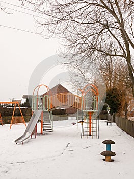 School children`s playground park climbing frame outside snow wi