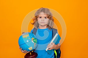 School children. School child with world globe and book. Portrait of school boy isolated on yellow studio background