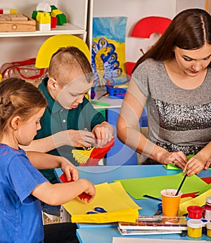 School children with scissors in kids hands cutting paper .